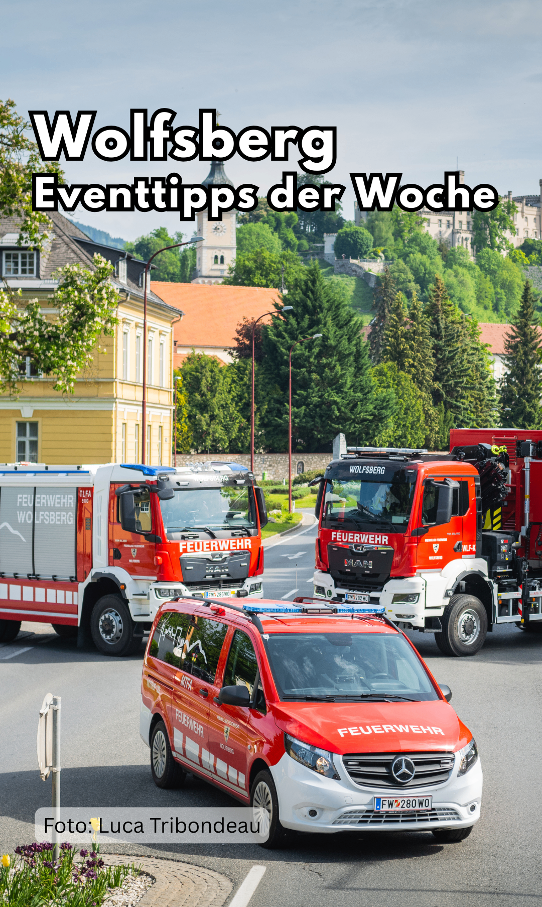 Two red fire trucks and a police vehicle on a road, with a yellow building and trees in the background. The word 'Feuerwehr' is visible on the trucks.