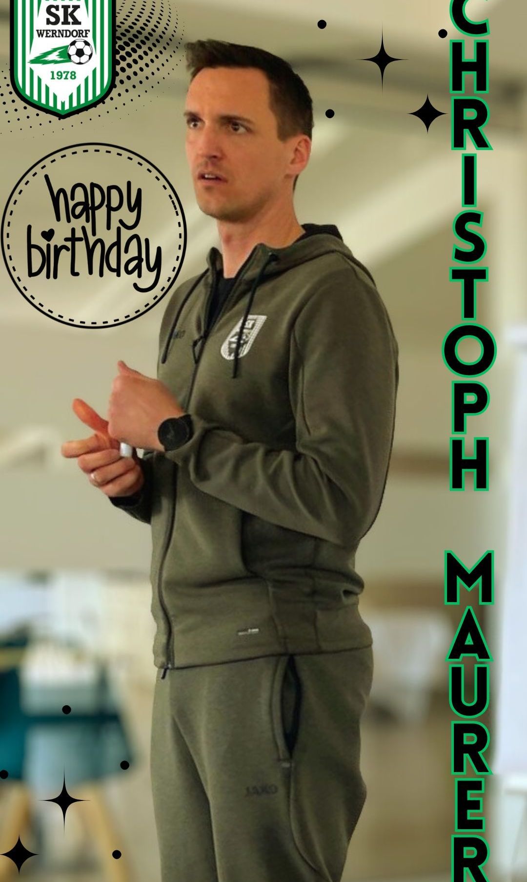 Ein Mann in einer grünen Kapuzenjacke mit dem Wort 'Happy Birthday' darauf, der Gesten mit den Händen macht.