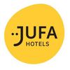 Das Jufa Hotels Logo ist auf weißem Hintergrund abgebildet. Das Logo zeigt einen stilisierten gelben Kreis mit dem Wort 'Jufa' in schwarzem und kursiv geschriebenem Stil. Darunter steht 'Hotels' in fetter schwarzer Schrift.