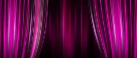 Ein Paar lila Theatervorhänge mit Licht, das von der Seite beleuchtet wird und einen dramatischen Effekt erzeugt.