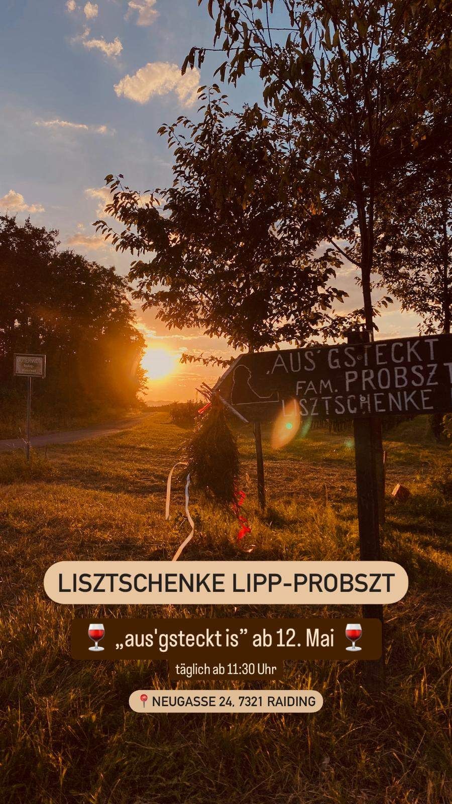 Ein Schild auf einem Pfosten zeigt 'Aus Gesteckt Fam Probszt Lisztschenke' mit einem Sonnenuntergang im Hintergrund. In der Nähe befindet sich ein Schild für 'Lisztschenke Lipp-Probszt'.