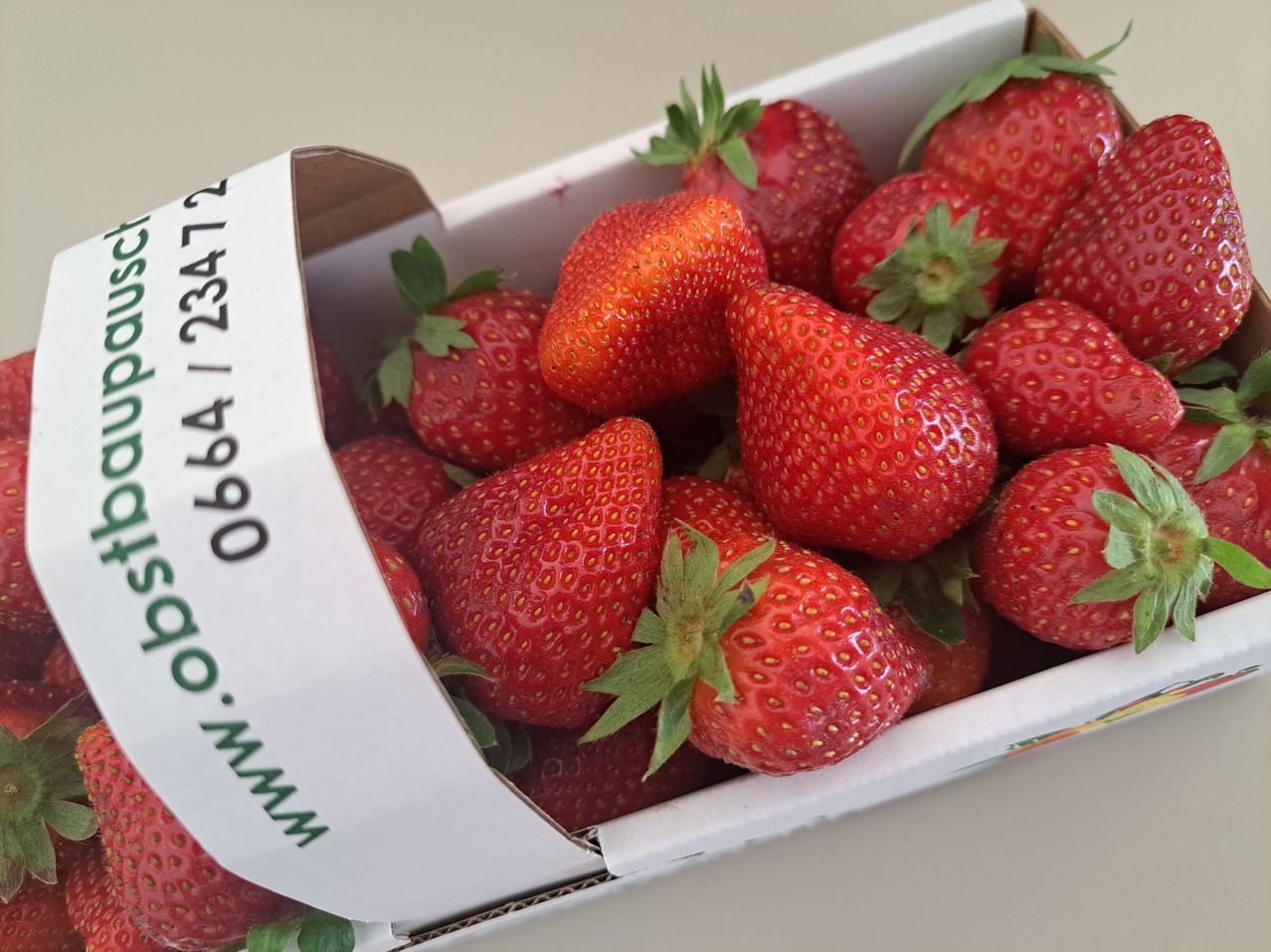 A box of strawberries with green leaves on top, labeled with the number 06641 23473.
