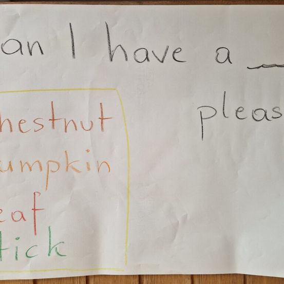 Eine handgeschriebene Notiz auf weißem Papier mit gelbem Rand. Die Notiz lautet 'Kann ich bitte eine Kastanie haben' mit 'Kastanie', 'Kürbis', 'Blatt' und 'Stock' hervorgehoben in Rot, Gelb und Grün.