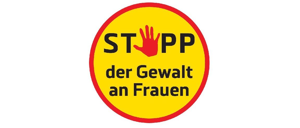 Ein gelber Kreis mit rotem Umriss enthält schwarzen Text, der 'STOPP der Gewalt an Frauen' lautet. Das Wort 'STOPP' ist fett und größer, während 'der Gewalt an Frauen' kleiner ist. Eine rote Hand ist in der Mitte abgebildet.