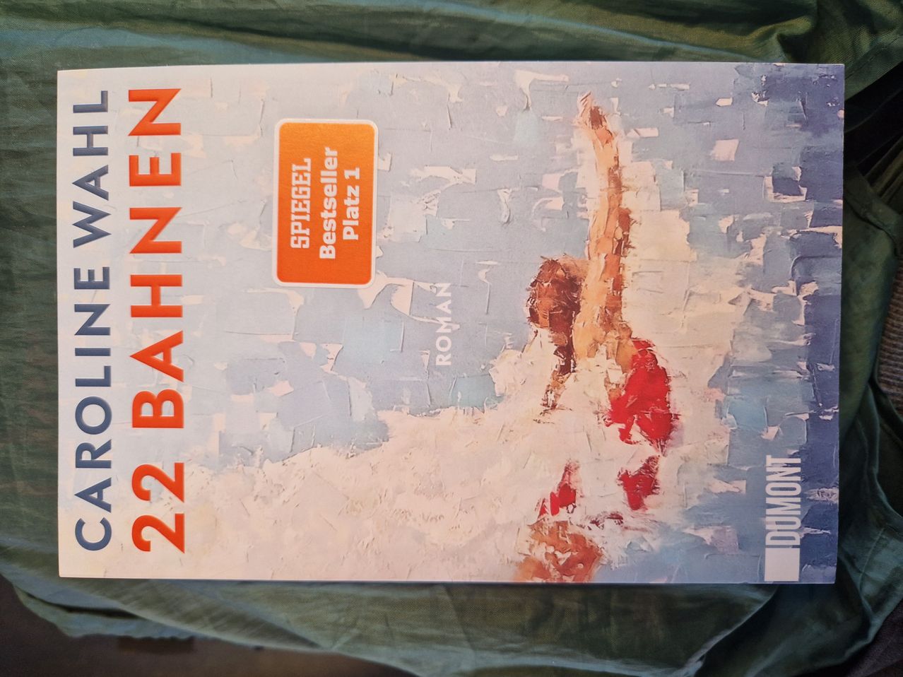 Buchcover für '22 Bahnen' von Dumont. Das Cover zeigt ein Gemälde eines Schwimmers in einem roten Badeanzug.