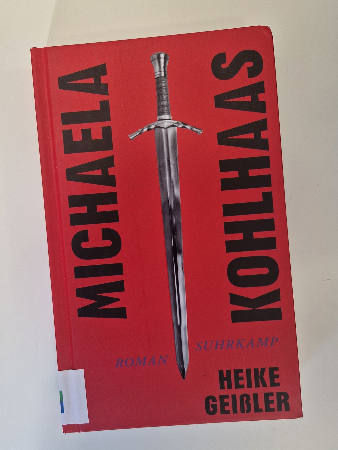 Ein rotes Buchcover mit einem silbernen Schwert und dem Titel 'Michael Kohlhaas' in schwarzem Text. Der Name der Autorin 'Heike Hekking' steht in Weiß unter dem Titel.