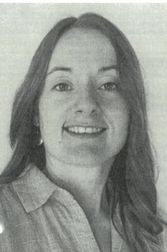 Ein Schwarz-Weiß-Porträt einer Frau mit langen Haaren, die ein Hemd mit Kragen trägt und mit sichtbaren Zähnen lächelt.