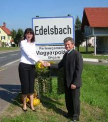 Bild enthält, Potted Plant, Advertisement, Neighborhood, Adult, Male, Man, Person, Female, Woman, Outdoors