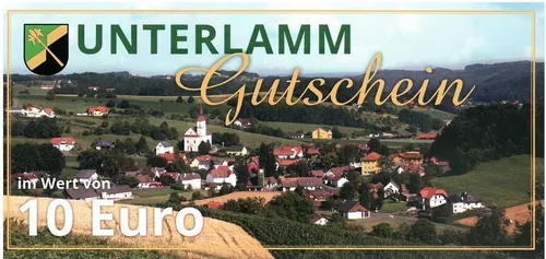Ein Dorf mit roten Dächern, einem weißen Kirchturm und einem Euro-Zeichen im Vordergrund. Grüne Hügel und Bäume umgeben das Dorf.
