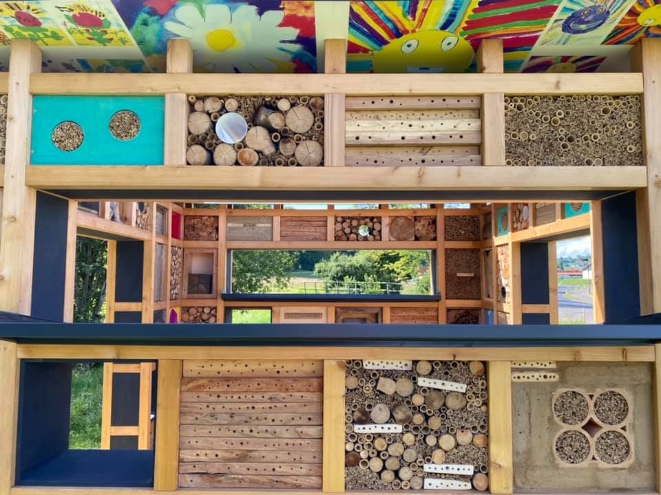 Nahaufnahme des Inneren eines Holzhauses mit buntem Dach, Fenster und einem Haufen Holzscheite an der Seite.