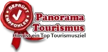 Das Bild zeigt ein rotes Siegel mit einem weißen Haken und den Worten 'Geprüft Panorama Tourismus'. Darunter befindet sich ein rotes Band mit dem Text 'Hier ist ein Top Tourismus Magazin'.