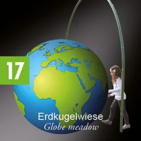 Ein junges Mädchen schiebt eine große Kugel mit der Nummer 17 darauf.