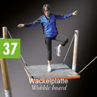 Eine Frau in einer blauen Jacke und schwarzen Hosen springt auf einem Wackelbrett.
