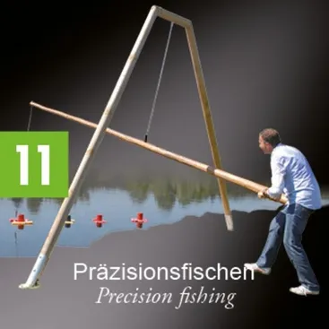 Ein Mann steht am Ufer eines Sees und hält eine Angelrute. Die Rute ist an einer Holzstruktur befestigt, auf der die Nummer 11 steht.