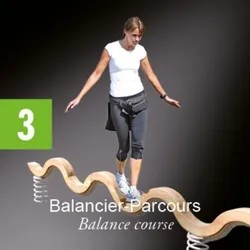 Eine Frau läuft auf einem hölzernen Balancebalken, trägt ein weißes T-Shirt, schwarze Hose und Turnschuhe.