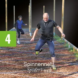 Zwei Personen laufen auf einem Spinnennetz-Hindernisparcours.