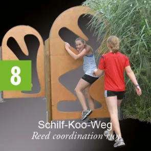 Zwei Mädchen laufen und klettern auf einem hölzernen Hindernisparcours. Das Mädchen auf der linken Seite klettert, während das Mädchen auf der rechten Seite neben ihr geht.