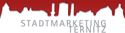 Ein roter und grauer Entwurf mit den Worten 'Stadtmarketing Ternitz' auf weißem Hintergrund. Der Entwurf hat ein stadtlandschaftsähnliches Muster mit roten Farbspritzern.