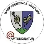 Das offizielle Wappen der Gemeinde Absdorf zeigt ein Kreuz, Weizen und eine Taube. Darunter steht in Rot das Wort 'Amtssiganatur'.