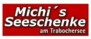 Ein rotes Schild mit weißem Text lautet 'Michi's Seeschenke am Trabochersee'. Der Text ist zentriert auf dem Schild.