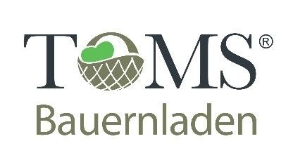 Das Logo für TOMS Bauernladen zeigt einen Korb mit einem Herzen darin und den Text 'TOMS' in fetter, schwarzer Schrift mit einem kleinen 'R'-Symbol am Ende. Darunter steht das Wort 'Bauernladen' in einer leichteren, grauen Schrift.