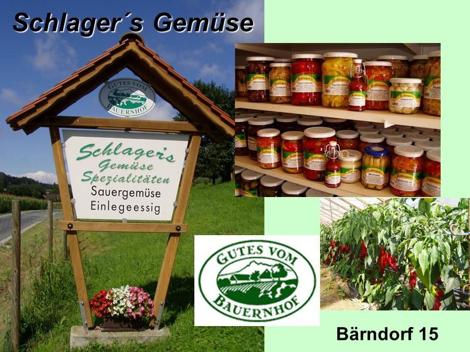 Ein Schild für Schlagers Gemüse Spezialitäten Sauergemüse Eingelegt, ein Glas mit Gemüse und eine Pflanze mit roten Chilischoten.