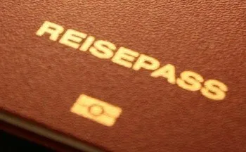 Eine Nahaufnahme eines braunen Reisepasses mit dem Wort Reisepass in Gold auf dem Cover. Ein kleines Logo befindet sich in der unteren rechten Ecke.
