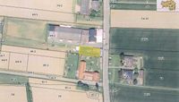 Eine Luftaufnahme zeigt ein ländliches Gebiet mit einem hervorgehobenen Grundstück, das mit 67/1 gekennzeichnet ist. Das Grundstück ist von landwirtschaftlichen Feldern, Straßen und anderen Grundstücken umgeben. Verschiedene Zahlen und Bezeichnungen sind um die Karte herum markiert.