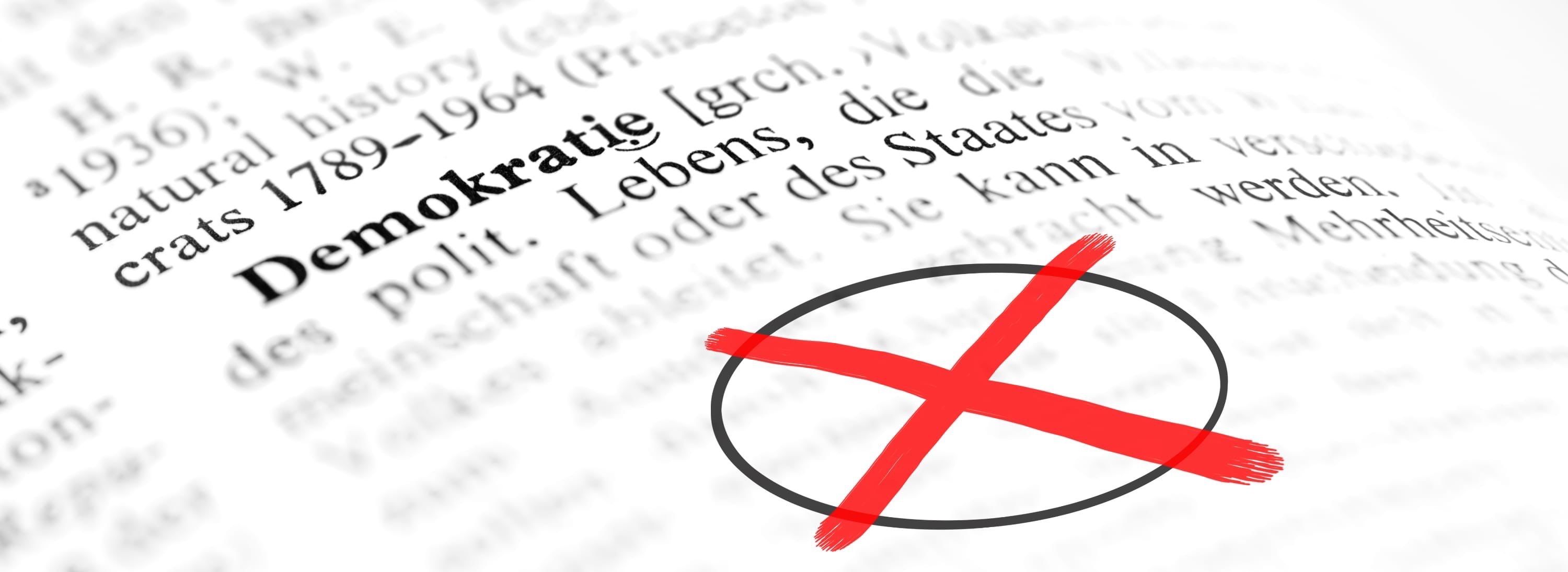 Ein Nahaufnahme einer roten Kreuzmarkierung auf einer Seite eines Buches mit dem Text 'Lebenstein' und 'die Staaten' auf Deutsch