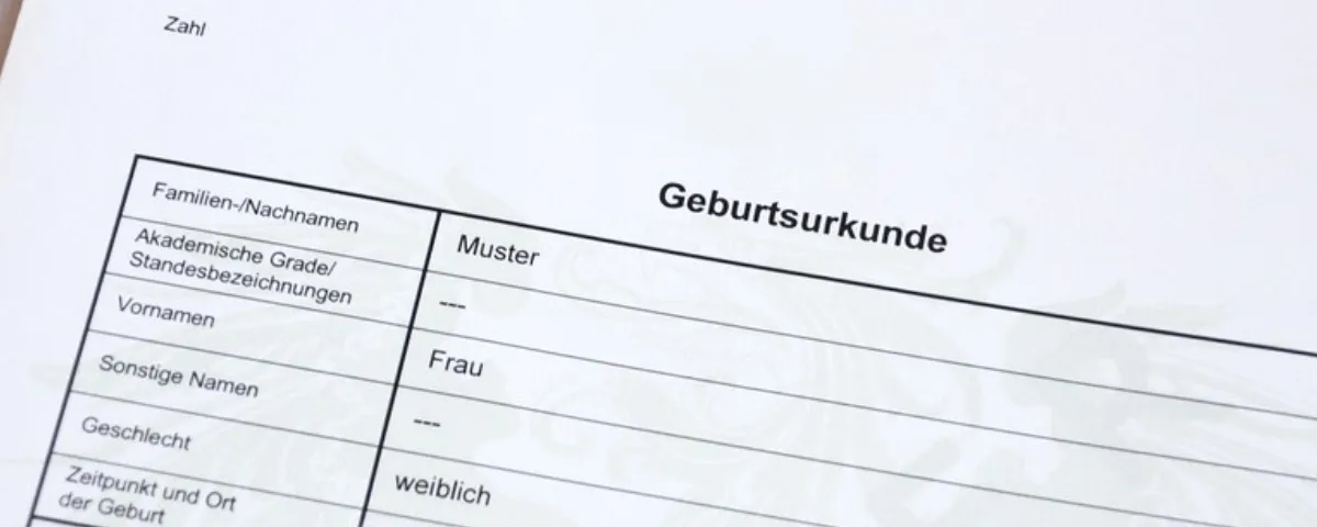 Ein weißes Blatt Papier zeigt ein Dokument mit dem Titel 'Geburtsurkunde' mit schwarzem Text, darunter 'Nachnamen', 'Muster', 'Grade/zeichnungen', 'Frau' und 'weiblich'.