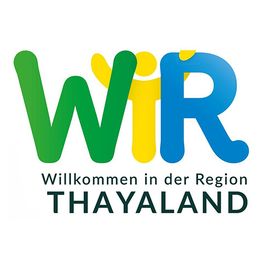 Logo für Wir, eine Willkommensinitiative in der Region Thailand mit einem farbenfrohen Design, das ein stilisiertes W und zwei Figuren zeigt.