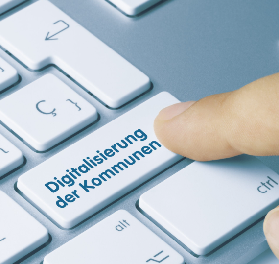  Abschnitt Bild: Ein Finger drückt auf die Taste, die Digitalisierung der Kommunen besagt. Andere Tasten sind ctrl, alt und Zahlen. Die Tastatur ist grau.