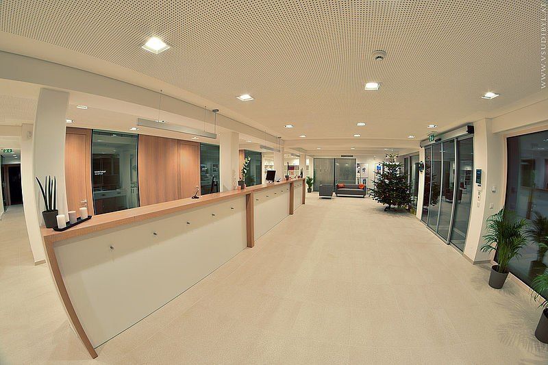 Bild enthält, Reception, Furniture, Table, Floor, Indoors, Flooring, Monitor, Foyer, Interior Design, Corridor