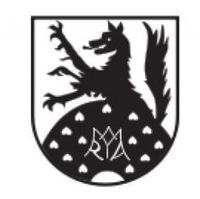 Ein schwarz-weißes heraldisches Wappen zeigt einen Wolf, der auf einem Herzensbett steht. Der Wolf hält ein Herz im Maul. Das Wappen ist von einem Kranz aus Herzen umgeben.