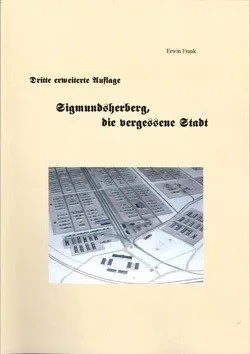 Ein beigefarbener Buchumschlag zeigt eine Karte eines Konzentrationslagers, betitelt 'Dritte erweiterte Auflage' und 'Zigmundshoberg, die vergessene Stadt'. Es enthält einen deutschen Namen 'Erwin Frank'.