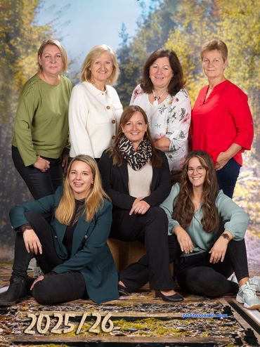 Eine Gruppe von Frauen posiert für ein Foto vor einem Hintergrund von Bäumen.