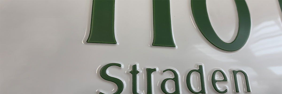 Eine Nahaufnahme eines weißen Schildes mit grünen Buchstaben, die die Zahl 10 und das Wort Strade buchstabieren.