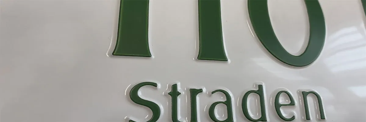 Eine Nahaufnahme eines weißen Schildes mit grünen Buchstaben, die die Zahl 10 und das Wort Strade buchstabieren.