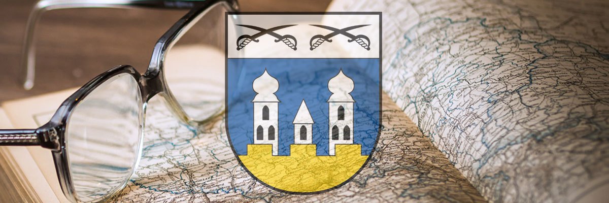 Ein Wappen mit zwei Türmen und gekreuzten Schwertern auf einer Karte, mit einer Brille obenauf.