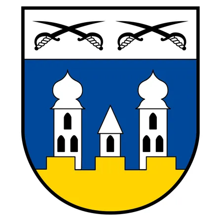 Ein heraldischer Schild mit einem blauen oberen und einem gelben unteren Abschnitt. Über dem Schild sind zwei gekreuzte Schwerter. Der blaue Abschnitt zeigt drei weiße Türme, wobei der mittlere kleiner ist.