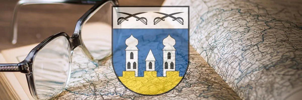 Ein Wappen mit zwei Türmen und gekreuzten Schwertern auf einer Karte mit einer Brille obenauf.