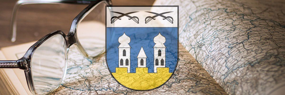 Ein Wappen mit zwei Türmen und gekreuzten Schwertern auf einer Karte, mit einer Brille auf der linken Seite.
