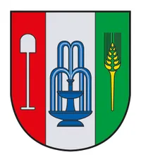 Ein Wappen, das in drei Teile geteilt ist: links rot mit einer Schaufel, mittig weiß mit einem blauen Brunnen und rechts grün mit einer Weizengarbe und einem gelben Stachel.
