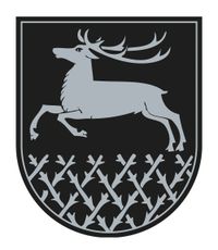 Ein Hirsch mit Geweih springt auf einem Schild mit einem Muster aus Zweigen und Ästen.