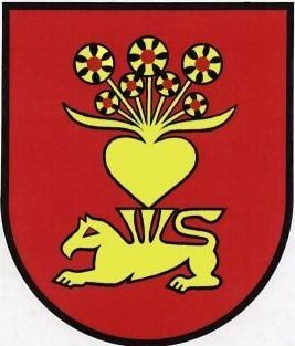 Ein roter Schild zeigt einen liegenden gelben Löwen mit einem gelben Herz und Blumen darüber. Das Herz hat einen gelben Rand und ein rotes Zentrum.
