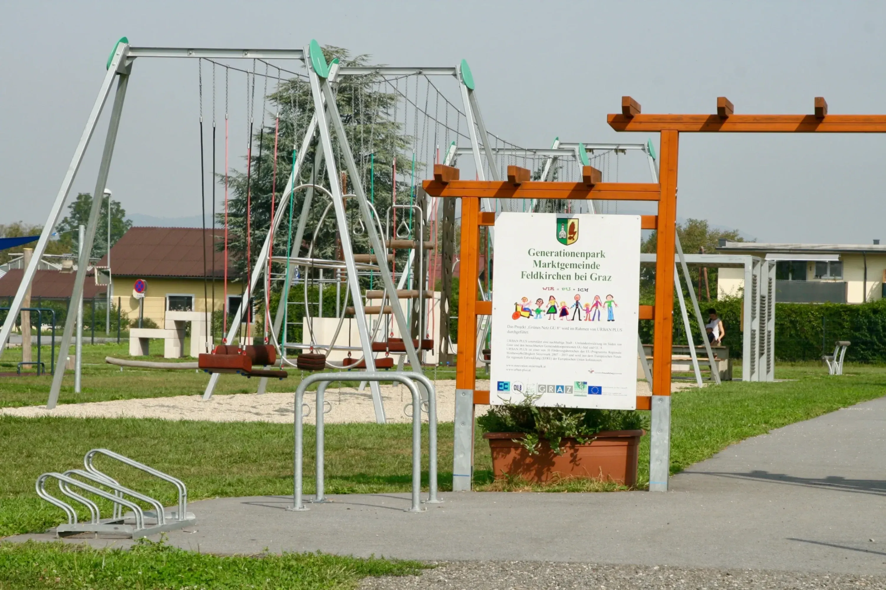 Generationenpark in Feldkirchen bei Graz mit Spielplatz und einem Informationsschild zum Park.