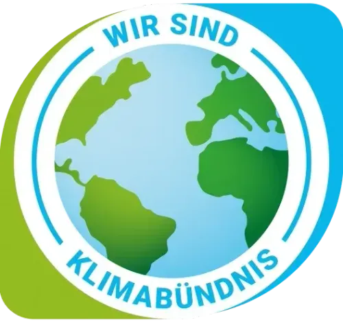 Ein kreisförmiges Logo mit dem Text 'WIR SIND' oben und 'KLIMABÜNDNIS' unten, umgeben von einer Weltkugel in blauen und grünen Farben.