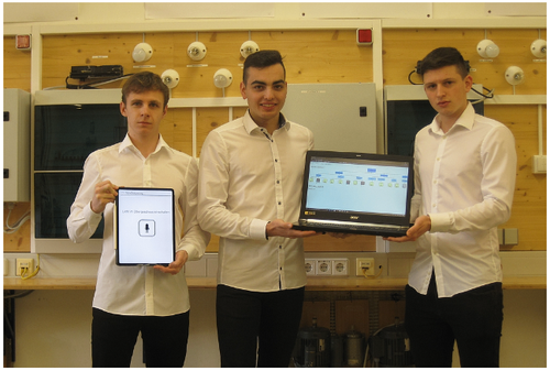 Drei Männer in weißen Hemden und schwarzen Hosen lächeln und posieren für ein Foto. Der Mann links hält ein Tablet, der Mann in der Mitte hält einen Laptop und der Mann rechts hält nichts.