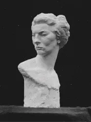 Ein Schwarz-Weiß-Foto einer Büstenskulptur, die eine Frau mit kurzen Haaren darstellt, die nach links schaut und die Augen geschlossen hat.