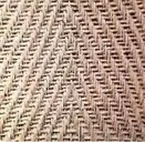 Nahaufnahme eines gewebten Materials mit einem Fischgrätmuster. Die Textur ist komplex und das Gewebe ist eng.